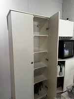 Open right cabinet door showing multiple shelving layers inside the storage cabinet.