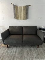 Front view of charcoal gray sofa with two seat and two back cushions, solid wood legs