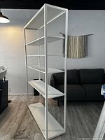 Side angle of white metal shelving unit showing structure and shelves