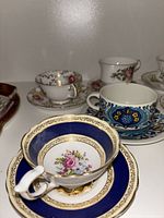 Close-up of front row teacup and saucer sets showing cobalt blue, floral and patterned designs