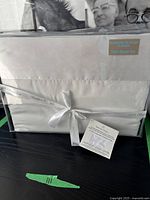 Packaged twin sheet set with label showing twin size and 100% satin hem.