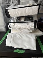 Two microfiber twin sheet sets in clear zippered bags stacked on top of each other with one white sheet folded.