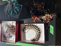 Overview of four costume necklace pieces including turquoise chunky beads, multi-colored beaded necklace, statement gold-tone black stone necklace, and other smaller bead necklaces