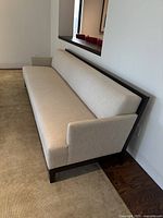 Full side view showing left arm, seat cushion, back cushion, and exposed dark wood frame