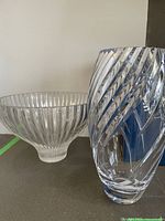 Mikasa crystal vase with spiral cut design in front of an Art vase bowl in background