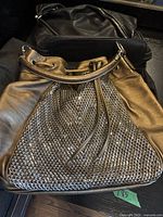 Two ladies purses including a brown Big Buddha purse with woven texture and a black Johnny Farah leather purse.