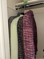 Four jackets hung on a closet rod showing full lot front view