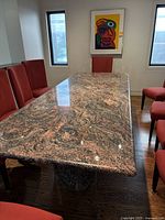 Full view of rectangular marble dining table with red-black veined top and cylindrical bases