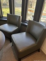 Front view of both chairs positioned by window, showing overall style and condition