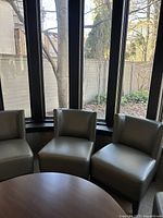 Three barrel chairs arranged in front of bay windows