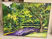 Full view of framed landscape painting with trees, vibrant greens and purples, metal frame