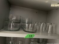 Glass dessert dishes and short drinking glasses on shelf, 5 each, clear rounded design.