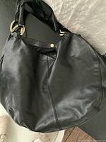 Overall view of the large black leather tote bag showing the front and softness of the leather material.