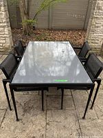 Full view of rectangular table with four chairs on patio