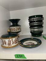 Blue and white ceramic vase, covered dish, ceramic plate, and stack of four clear glass bowls with green rims on a white shelf.