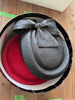Photo showing the red wool Harrods hat inside round storage box.