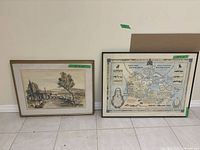 Two framed artworks side by side on the floor. The left artwork is a watercolor painting of a rural landscape with trees. The right artwork is a framed map of Canada related to the Royal Canadian Mounted Police.