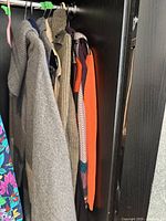 Overview of six knit garments hanging on rack