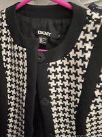 Close-up of DKNY label and black & white houndstooth pattern on blazer.