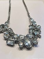 Front view of the 1950s vintage rhinestone chain necklace showing the arrangement of clear rhinestones cluster on a silver-tone chain.