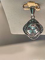 Front view of the .925 silver pendant showing large central clear Swarovski crystal surrounded by smaller blue-green crystals.