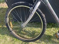 Close-up of front wheel tire and fork suspension showing knobby tread pattern and metal front fork.