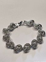 Photo of the vintage silvertone link bracelet laid flat, showing interlocking textured oval links and clasp.