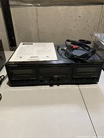 Front view of the Pioneer CT-W550R stereo double cassette deck showing the cassette compartments, controls, digital display, included RCA cables and operating instructions on top of the unit.