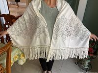 Shawl worn showing full lace pattern and long fringes on edge