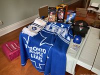 Photo showing all items including Toronto Maple Leafs throw and scarf, bobbleheads, hats and hockey cards.