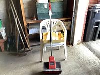 Full view of the Toro electric snow shovel with white chair and shelf in background
