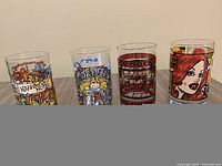 Front view of four colorful vintage glass tumblers side by side on surface, visualizing all designs.