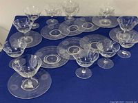 10 low sherbet glasses and 10 sherbet plates displaying floral Cornflower etching on clear glass with star pattern in center of plates.