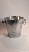 Side view of the vintage metal ice bucket showing its cylindrical shape and ring handles.
