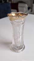 Full view of the vase showing clear press glass detail and worn gilded top rim
