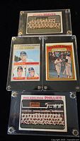 Four encased vintage baseball cards shown: Atlanta Braves team card, 16-69 American League ERA Leaders card, 1971 AL Playoffs card, Philadelphia Phillies team card.