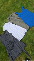 Four women's casual dresses laid out on grass, showing all dresses in one frame.