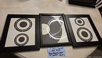 Set of three framed music-themed art prints showing two speaker prints and one vinyl record player print in the center.
