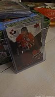 Holographic Joe Sakic Upper Deck hockey card showing player in red Canada jersey, numbered 146/225, in protective case.