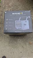 Box showing Maxheat electric garage heater with adjustable thermostat, energy-saving feature, heats up to 750 sq ft, and remote control.