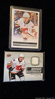 Two hockey cards featuring Johnny Gaudreau, one standard rookie card and one memorabilia patch card.
