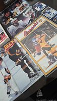 Photo showing 3 hockey cards laid out including one with player in black and orange uniform and a Beckett card
