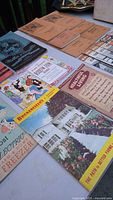 Booklets arranged side by side on a table, showing titles and cover illustrations related to vintage educational topics such as health, diet, and homemaking.
