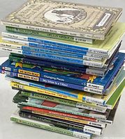 Stacked view of 18 children's books showing spine titles and reading program labels