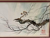 Framed painting showing birds perched on a branch with light green background tones and black and brown brushwork.