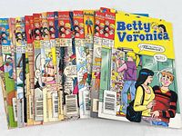 21 vintage Archie comic books fanned out showing colorful covers of Betty and Veronica