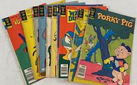 Lot of 11 vintage Gold Key comic books with covers showing various characters including Porky Pig, Bugs Bunny, Mickey Mouse, Goofy, Yosemite Sam, and Woody Woodpecker laid out fanned for display.