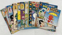 Photo shows a group of 16 vintage Harvey comic books fanned out with colorful covers featuring various characters such as Hot Stuff and Little Dot, in used condition with intact covers.