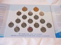 Coins arranged neatly inside a collector card, 25 coins in total with Olympic themed designs visible.