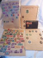 Photo showing multiple album pages and sheets containing a variety of used U.S. postage stamps in assorted colors and designs.